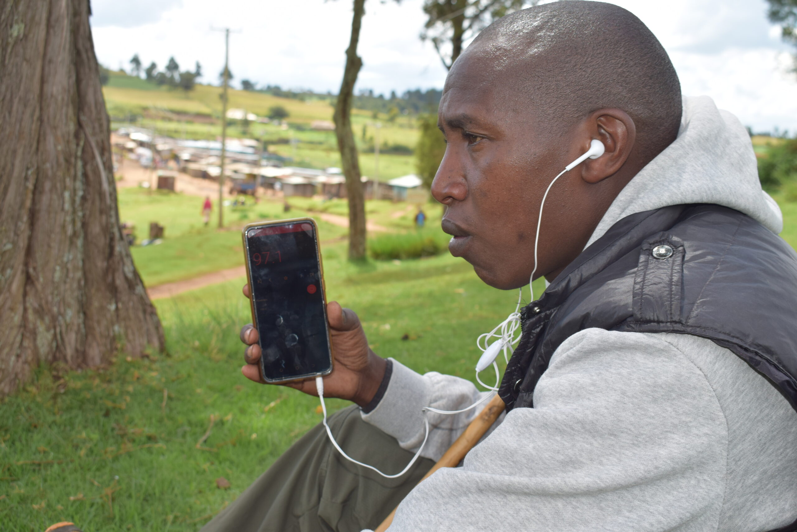 Alex Kisioi tuned to Sogoot fm radio and seated under a tree, meters away from Mariashoni centre, Molo Nakuru County Kenya.